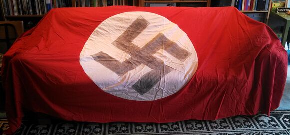 "It will be good to get it out of our house" – Hakenkreuzflagge, ausgebreitet über dem heimischen Sofa in Bainbridge Island, USA. (Privat/ D-DZO 0177-03)